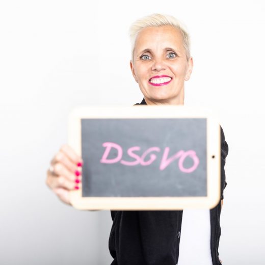 Christiane Henneken - Rechtsanwältin und DSGVO-Expertin für pragmatische Datenschutzlösungen; mit Tafel DSGVO in der Hand